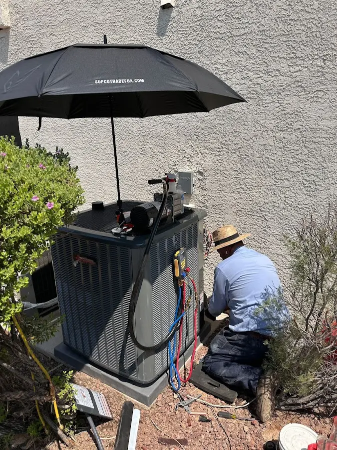 HVAC technician performing outdoor AC maintenance in Lewistown