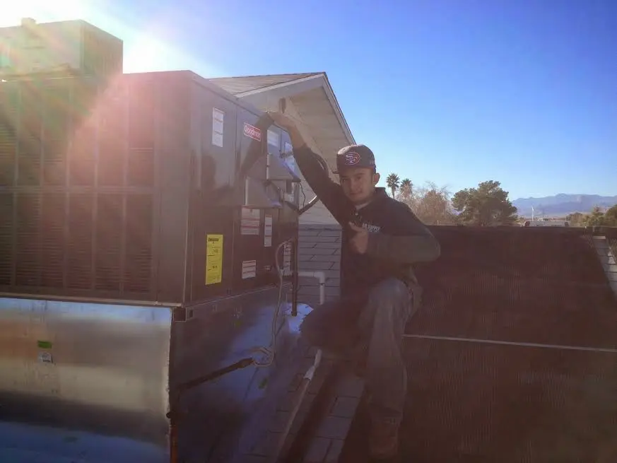 HVAC technician performing Boiler Repair on a rooftop unit in Lewistown